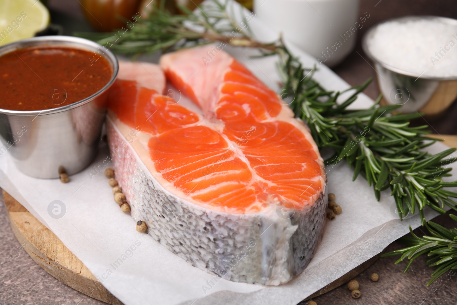 Photo of Fresh fish, rosemary and marinade on table, closeup