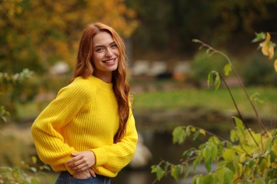 Portrait of happy woman in autumn park. Space for text