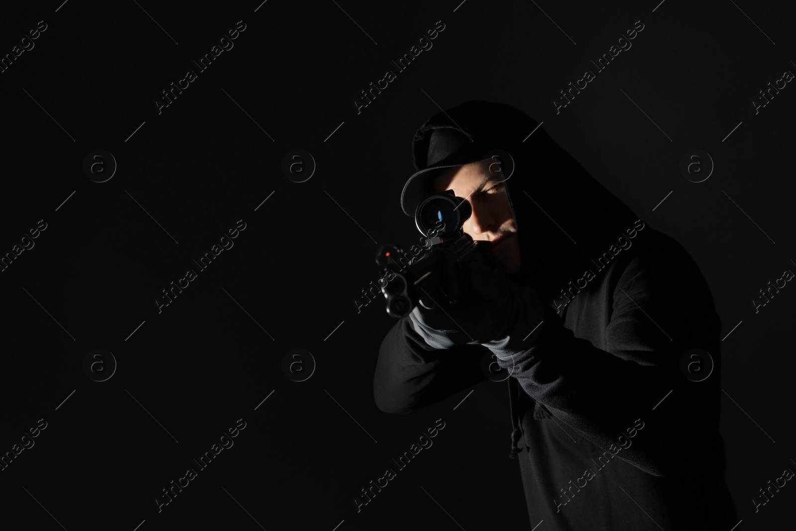 Photo of Professional killer with sniper rifle on black background