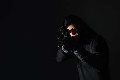 Professional killer with sniper rifle on black background