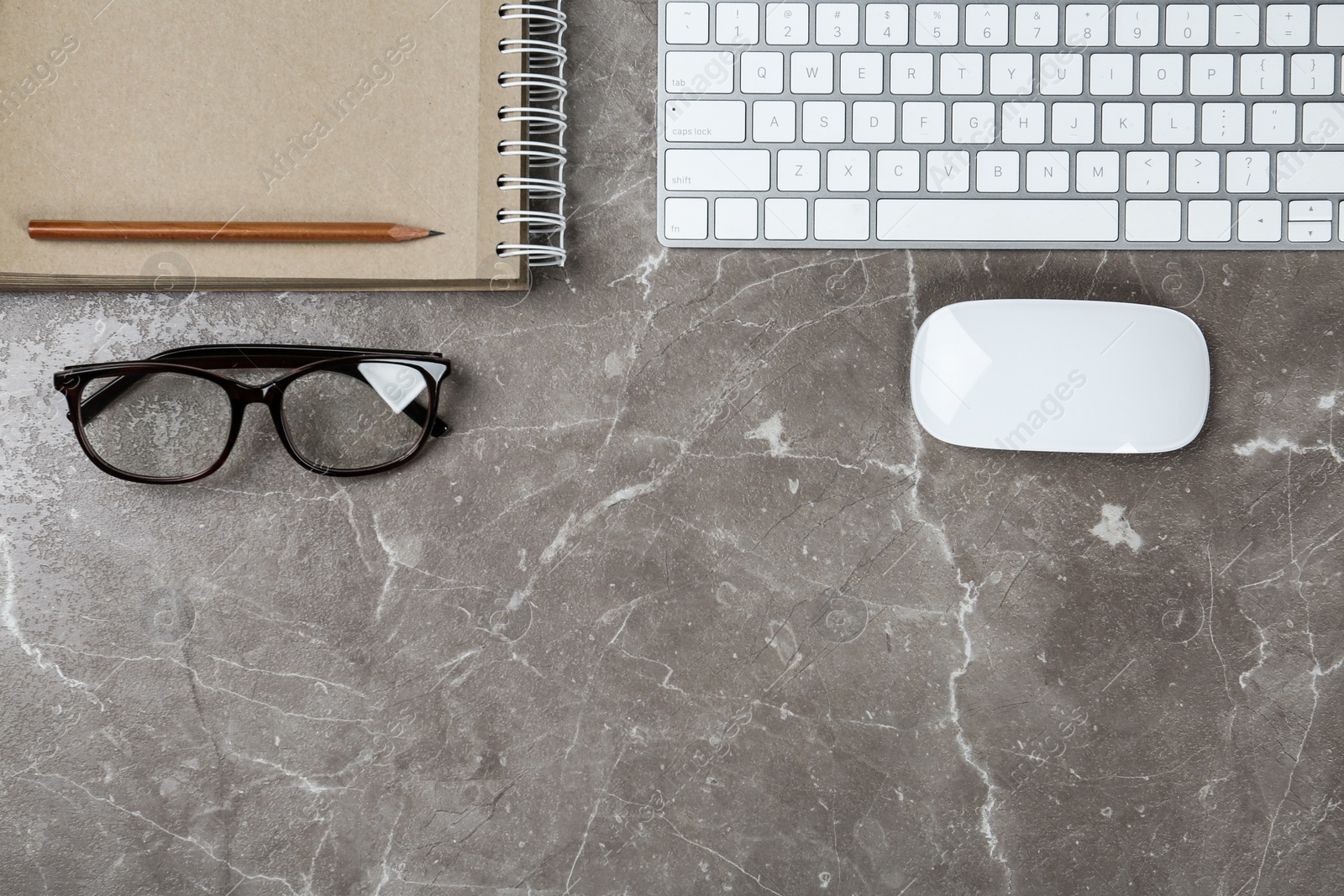 Photo of Flat lay composition with computer keyboard and notebook on marble background, space for text. Graphic designer's workplace