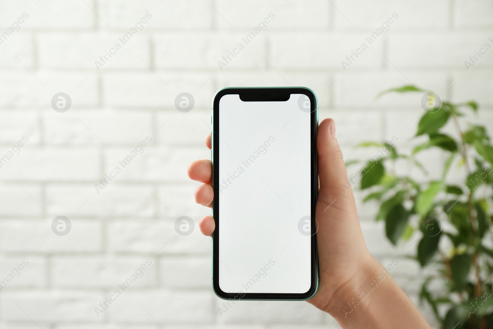 Photo of MYKOLAIV, UKRAINE - JULY 8, 2020: Woman holding Iphone 11 Pro Max with blank screen indoors, closeup