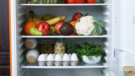 Photo of Open refrigerator full of many different products