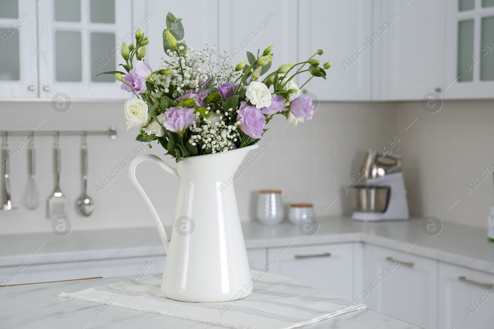 Photo of Beautiful bouquet with Eustoma flowers on table in kitchen