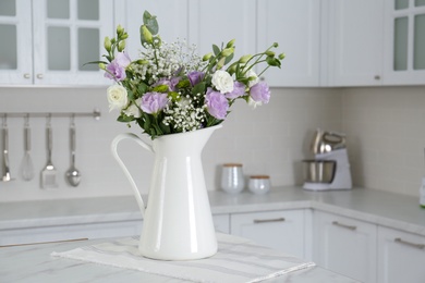 Beautiful bouquet with Eustoma flowers on table in kitchen