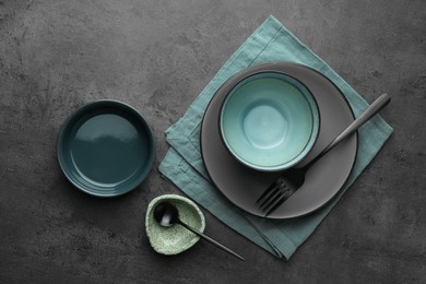 Photo of Stylish empty dishware and cutlery on grey table, flat lay