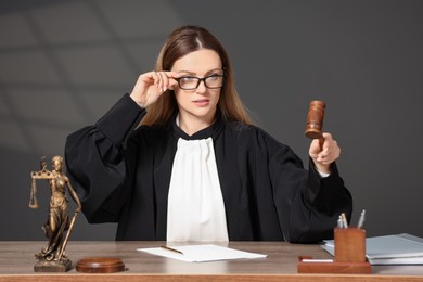 Judge striking mallet at wooden table indoors