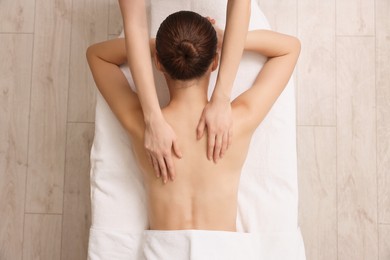 Photo of Woman receiving back massage on couch in spa salon, top view