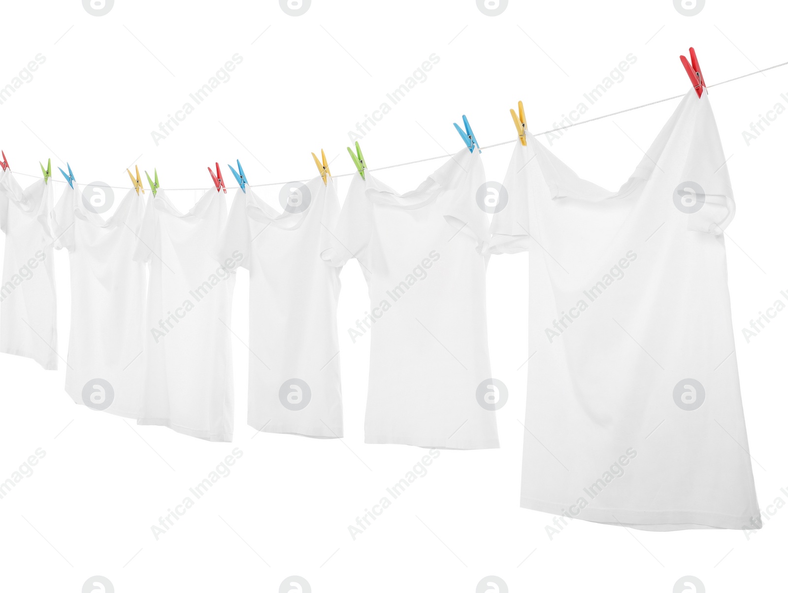 Photo of Many t-shirts drying on washing line isolated on white