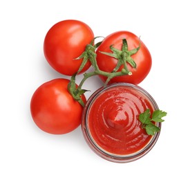 Photo of Tasty ketchup in glass jar and fresh tomatoes isolated on white, top view