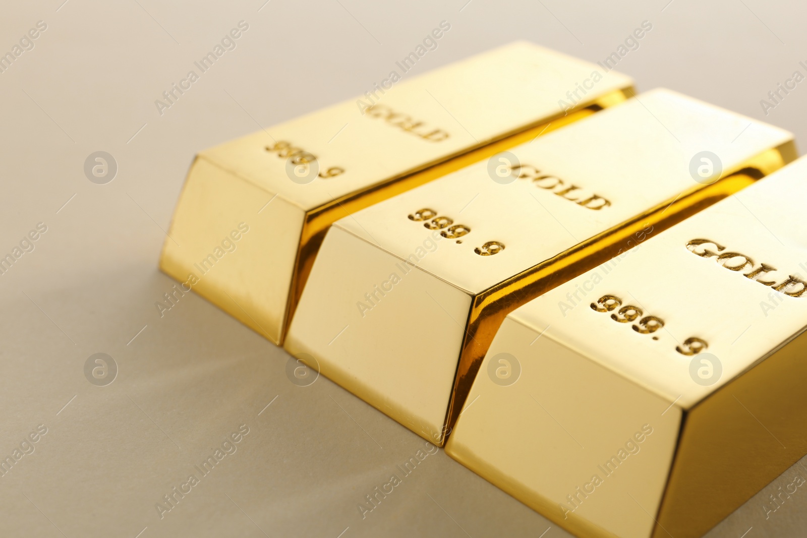 Photo of Precious shiny gold bars on light background