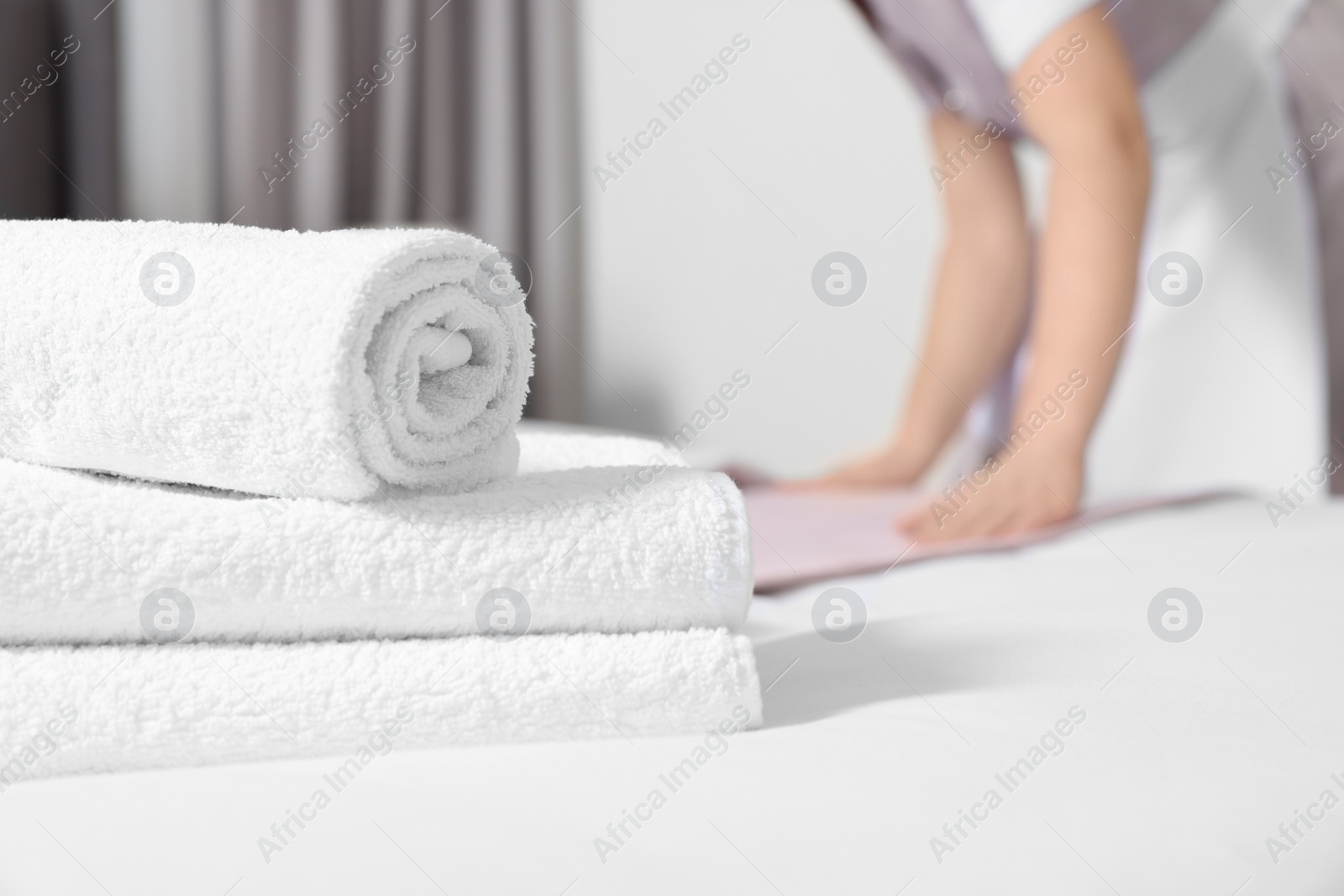 Photo of Maid making bed in hotel room, closeup. Space for text