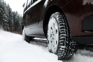 Photo of Closeup view of car in snow near road. Space for text