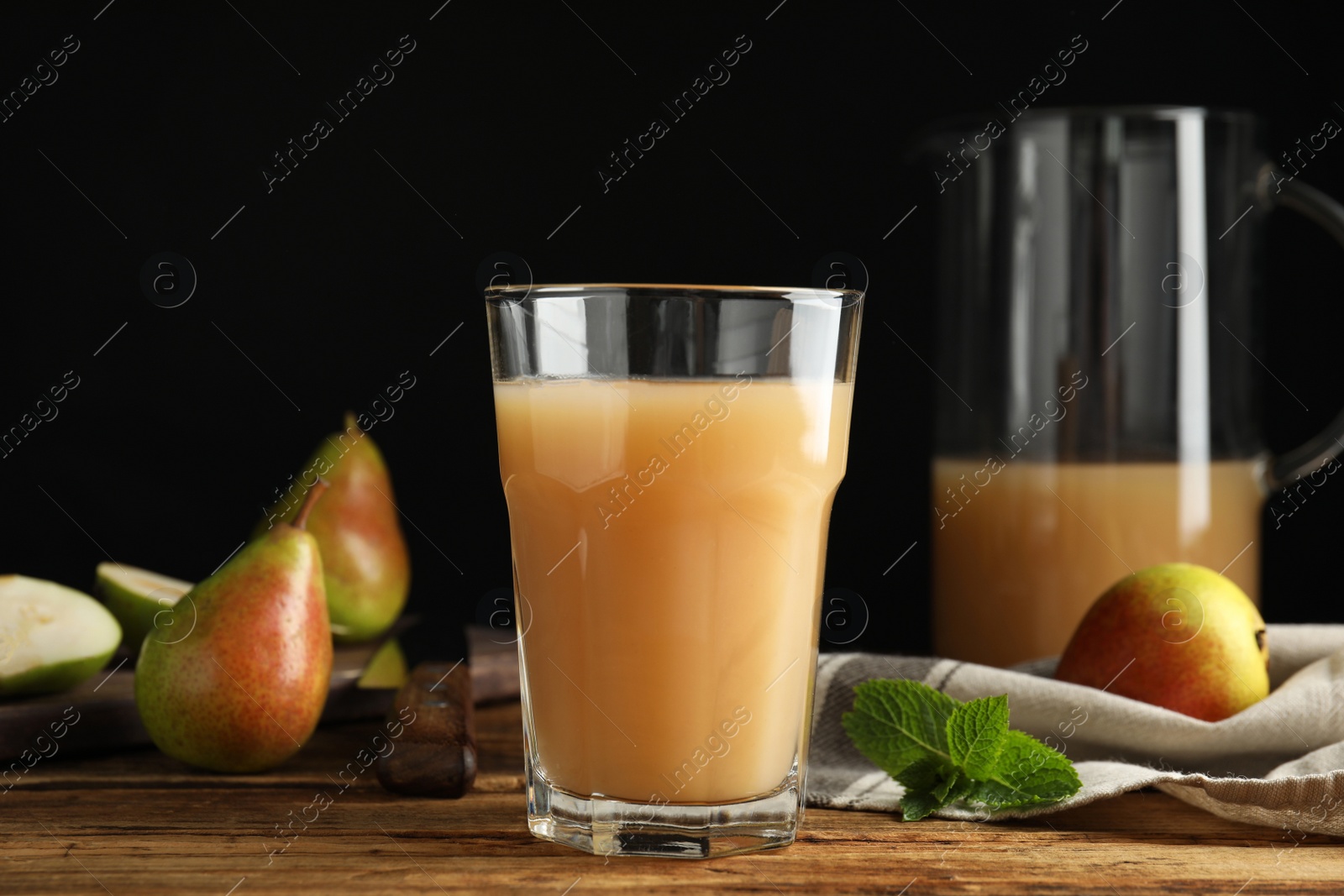 Photo of Fresh pear juice in glass on wooden table, closeup