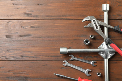 Auto mechanic's tools on wooden background, flat lay. Space for text