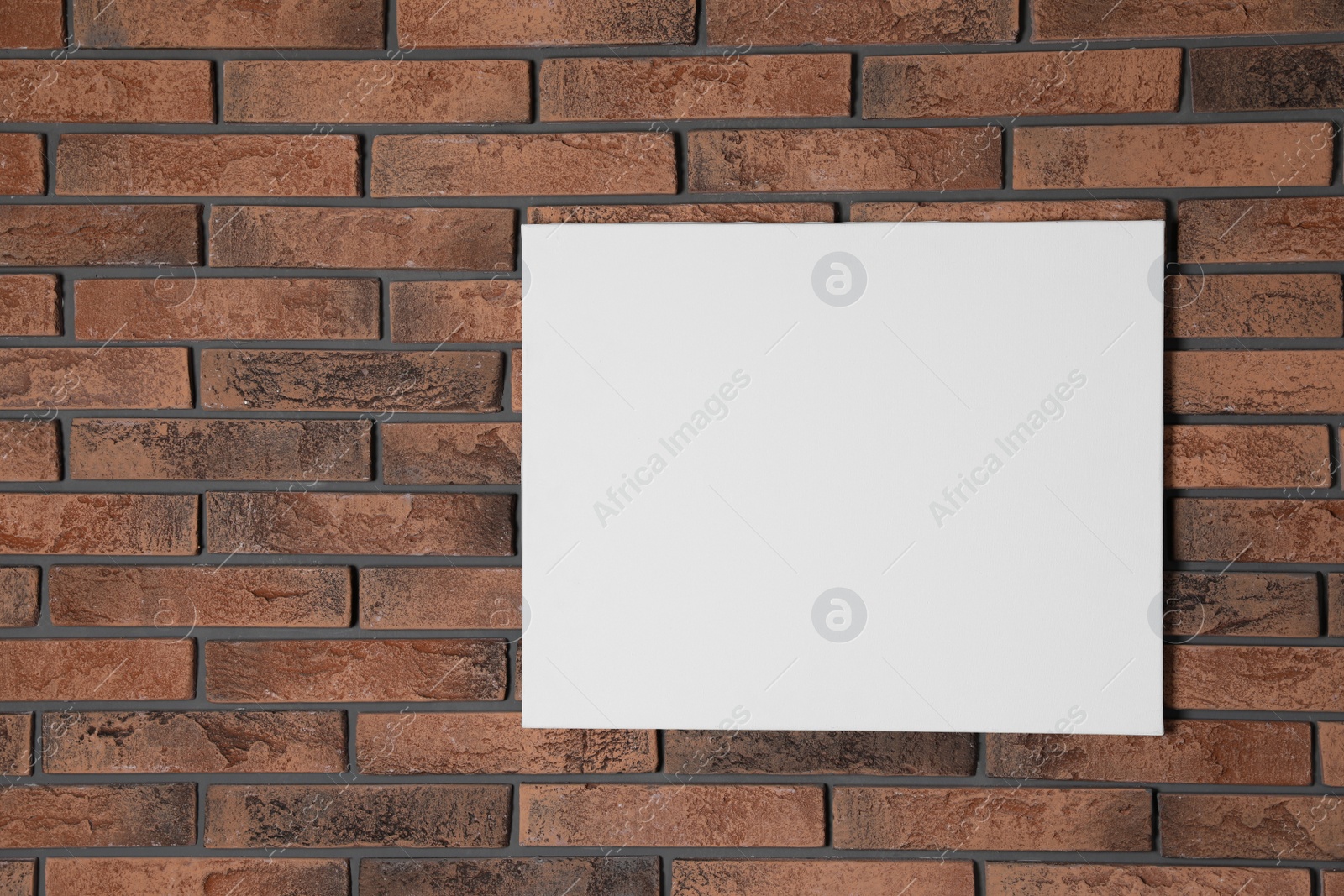 Photo of Blank canvas on brick wall. Space for design