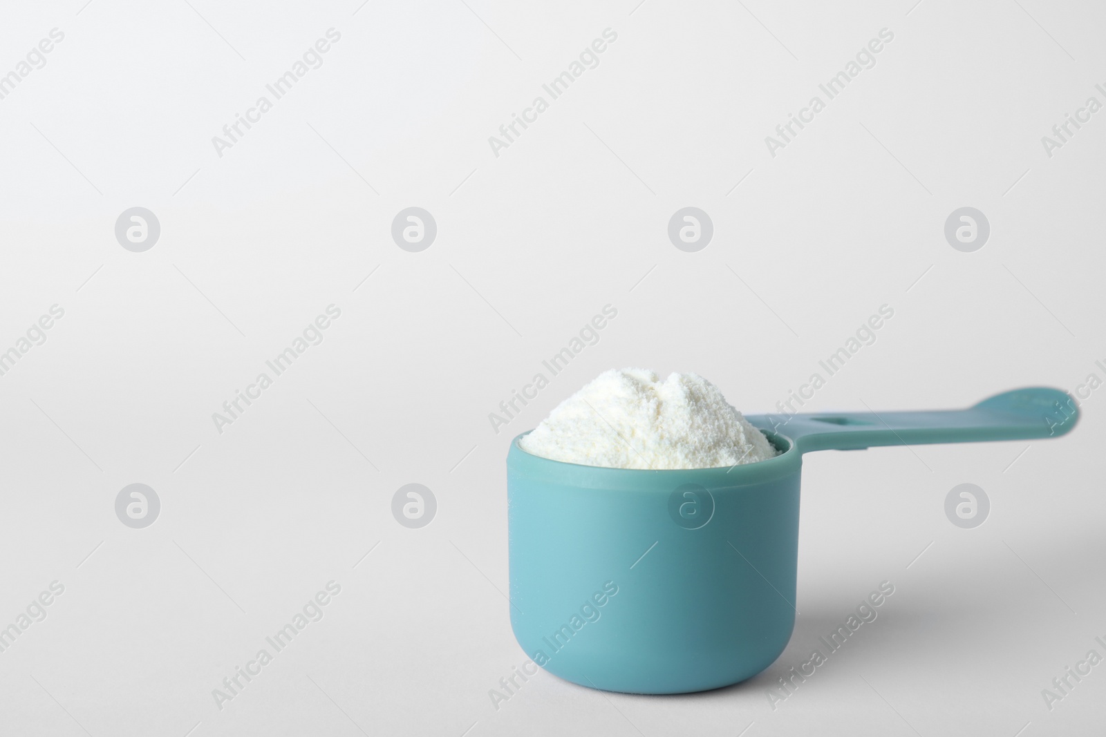 Photo of Scoop of protein powder on white background, space for text