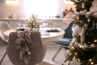 Photo of Grey chair with beautiful Christmas decor in kitchen. Interior design