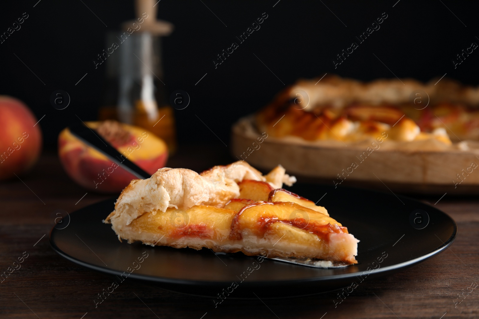 Photo of Piece of delicious fresh peach pie served on wooden table