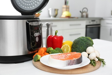 Modern multi cooker and products on kitchen table