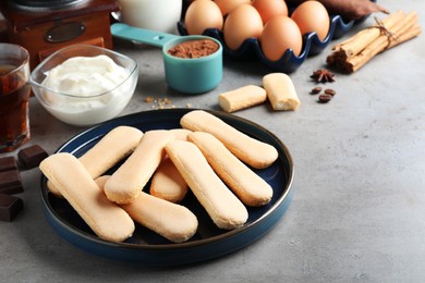 Photo of Tasty cookies and other ingredients for tiramisu on grey table