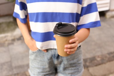 Coffee to go. Woman with paper cup of drink outdoors, selective focus