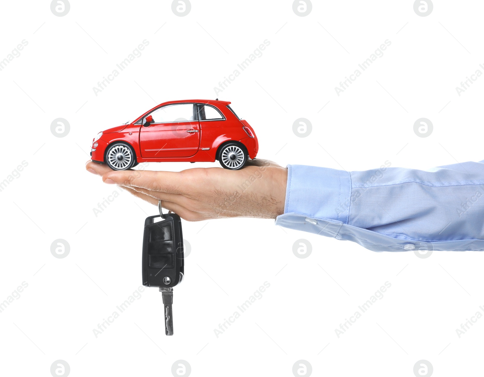 Photo of Man holding key and miniature automobile model on white background, closeup. Car buying
