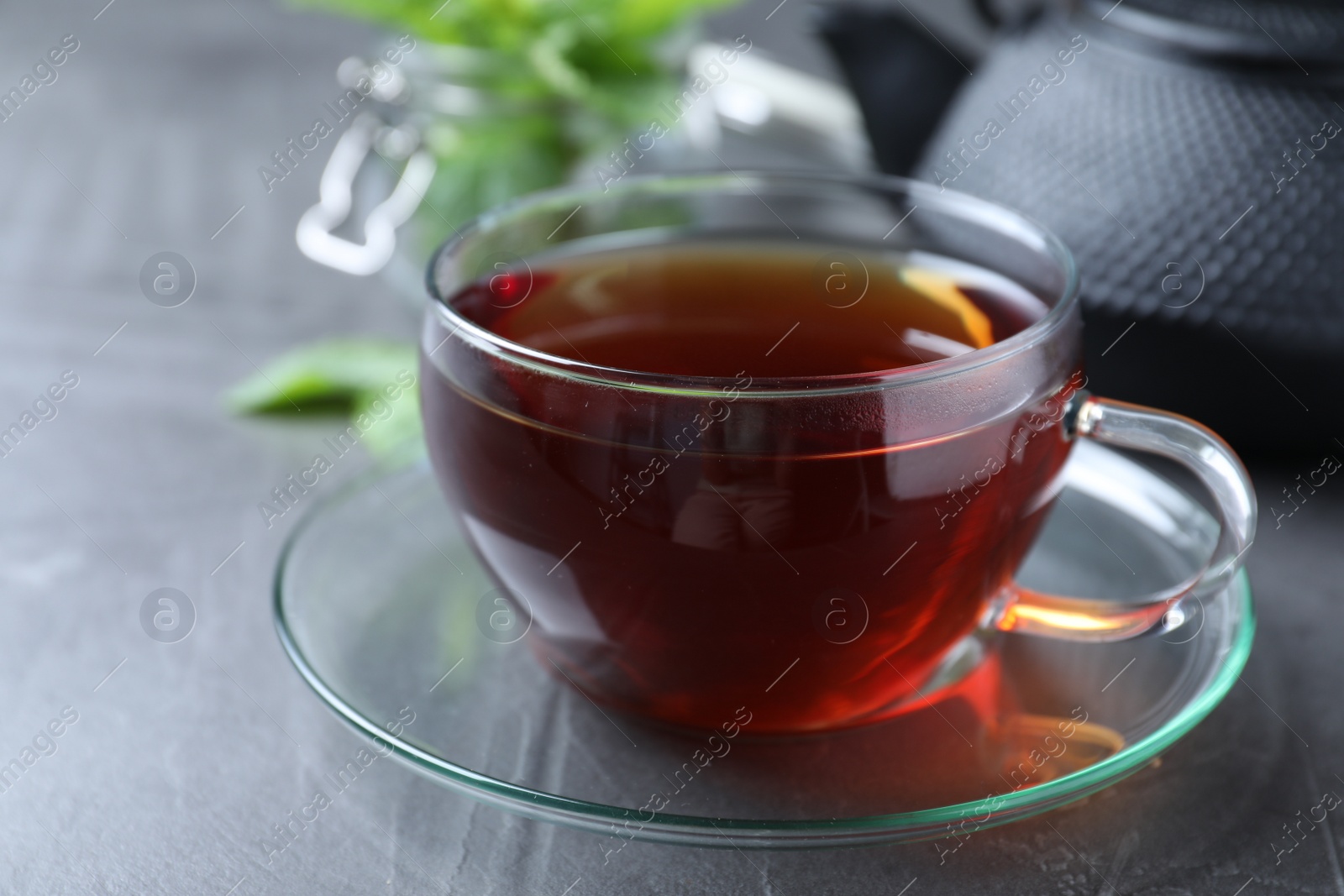 Photo of Fresh tea with mint on grey table, closeup