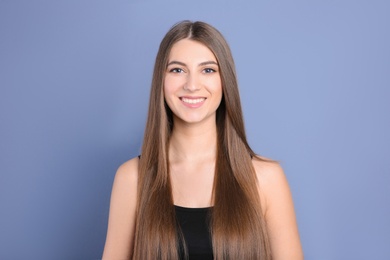 Portrait of young woman with long beautiful hair on grey background