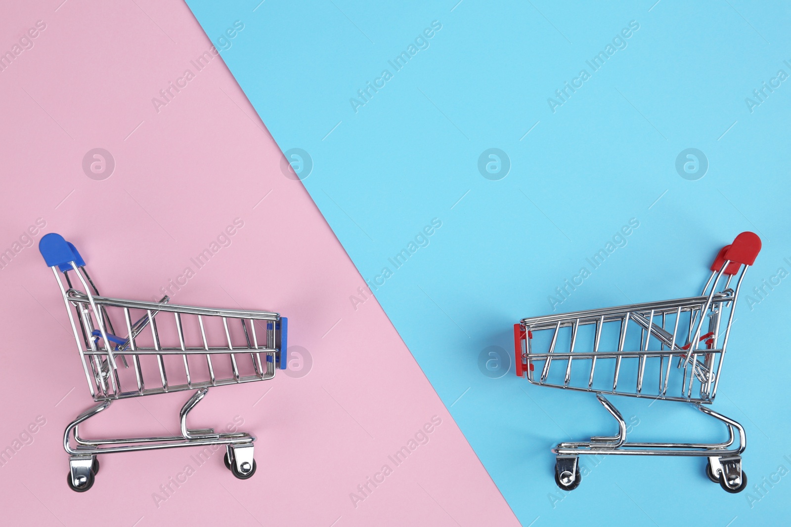 Photo of Flat lay composition with empty shopping trolleys on color background. Space for text