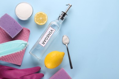 Photo of Eco friendly natural cleaners. Flat lay composition with bottle of vinegar on light blue background, space for text