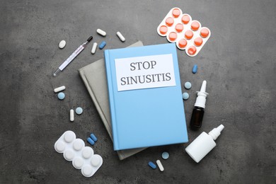 Photo of Notebook with phrase STOP SINUSITIS, thermometer and different drugs on grey stone background, flat lay