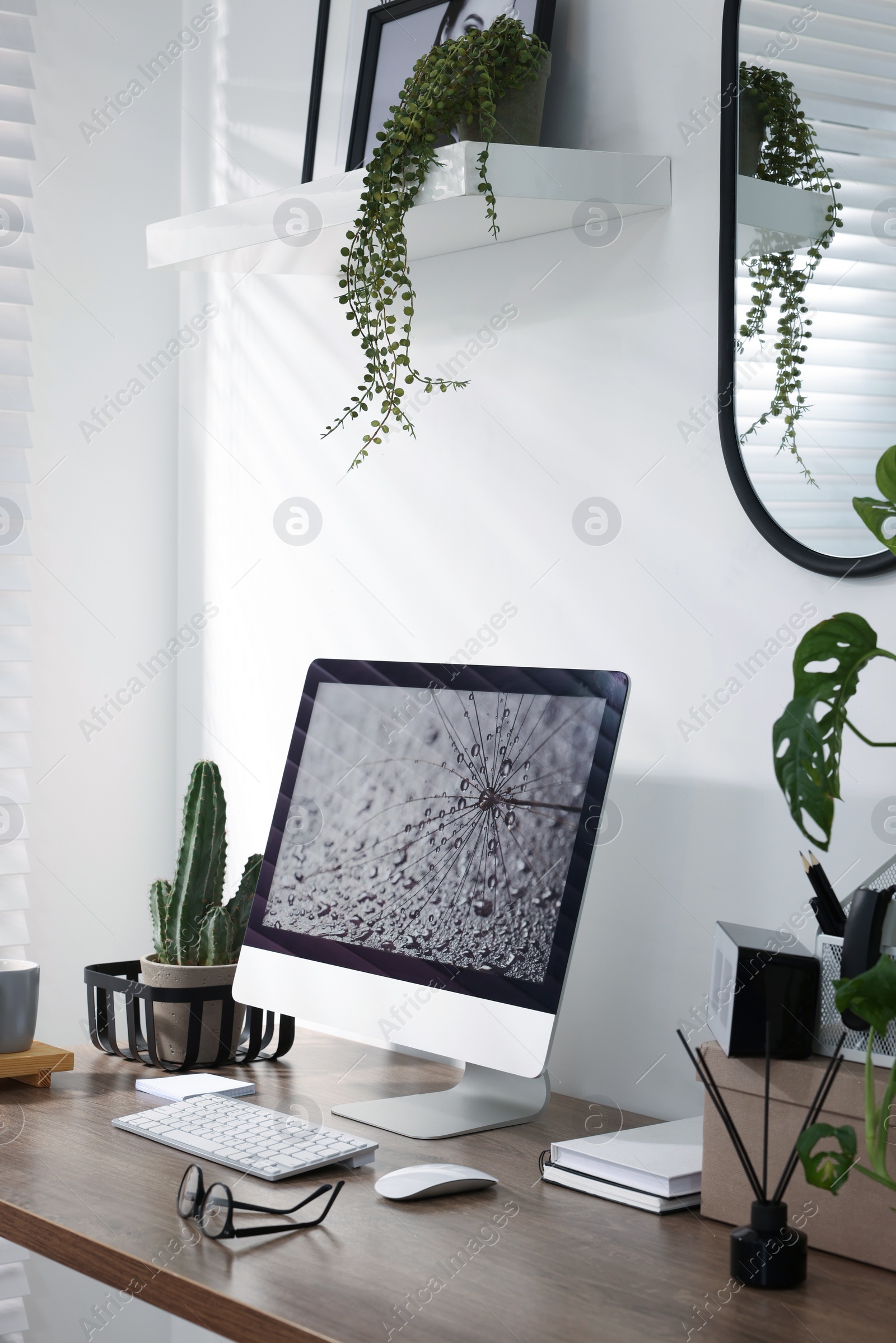 Photo of Cozy workspace with computer on wooden desk at home