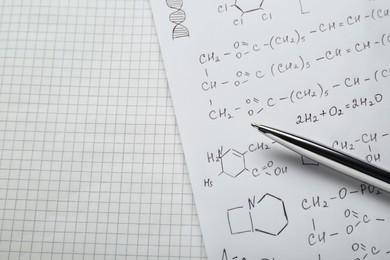 Sheets of paper with different chemical formulas and pen, above view. Space for text