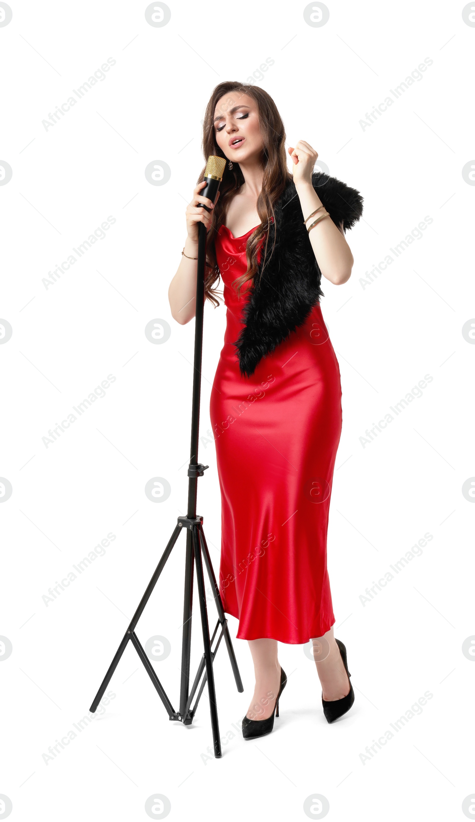 Photo of Beautiful young woman in stylish red dress with microphone singing on white background