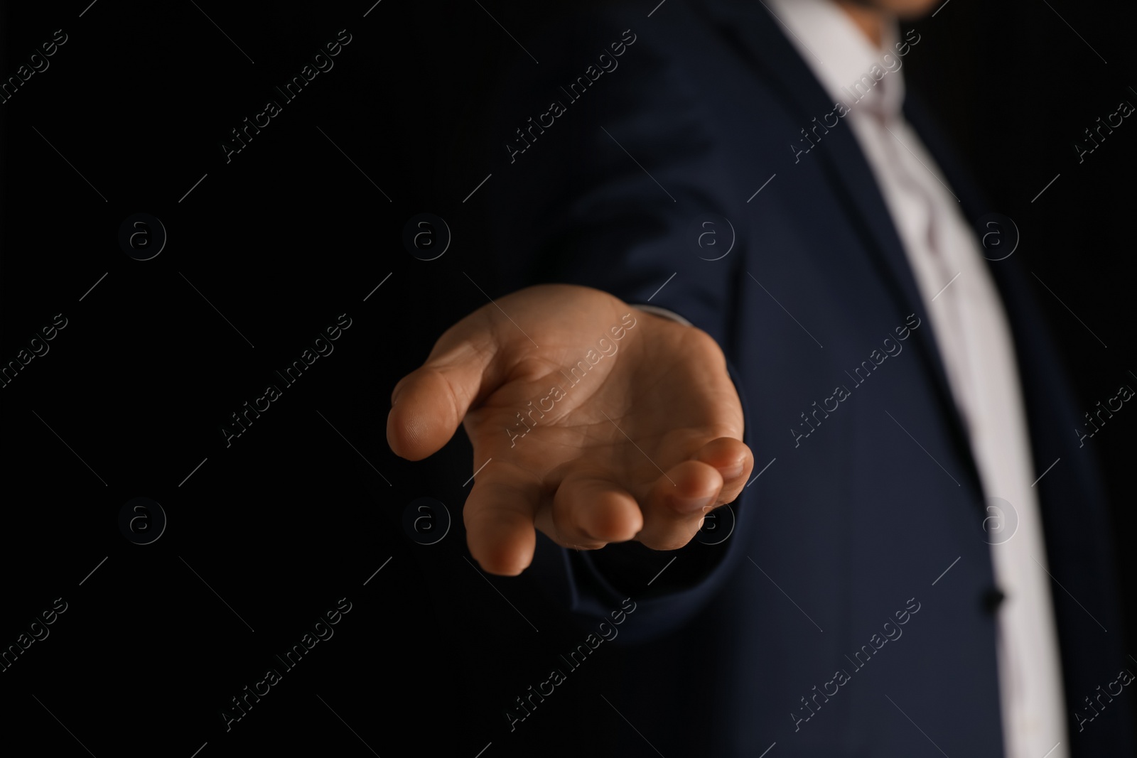 Photo of Man holding something on black background, closeup