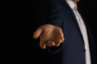 Photo of Man holding something on black background, closeup