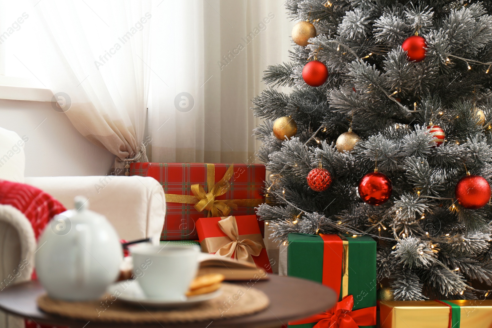 Photo of Stylish room interior with beautiful Christmas tree and gift boxes