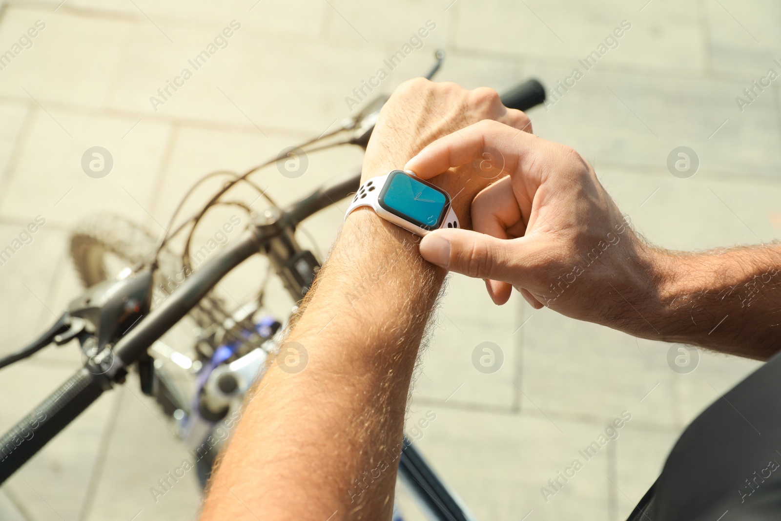 Photo of Man using modern smart watch during training outdoors, closeup