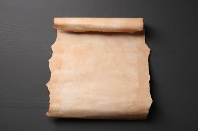 Photo of Sheet of old parchment paper on light grey wooden table, top view. Space for text