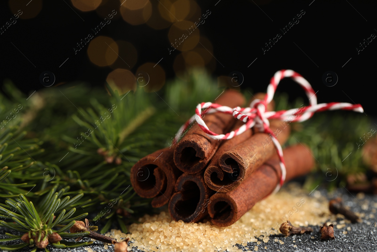 Photo of Different aromatic spices and fir branches on grey textured table, closeup