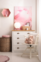 Stylish child's room interior with beautiful picture and chest of drawers