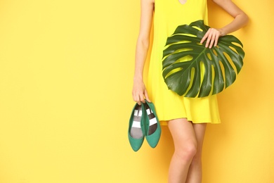 Photo of Young woman with elegant shoes on color background, closeup