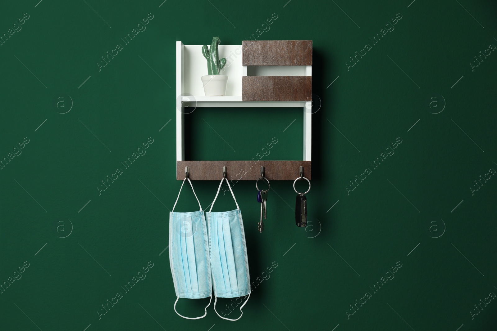 Photo of Wooden hanger for keys on green wall