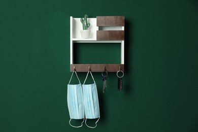 Photo of Wooden hanger for keys on green wall