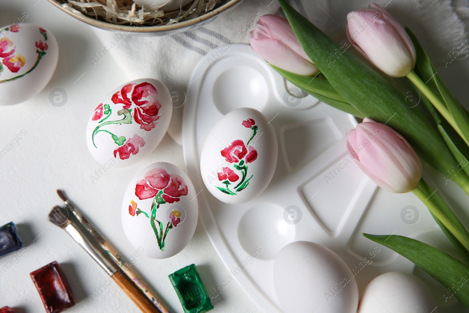 Photo of Painting Easter eggs on white table, flat lay