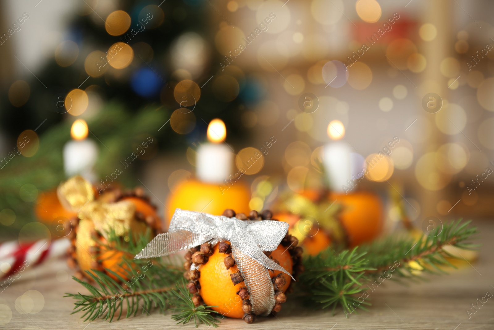 Photo of Pomander ball made of fresh tangerine and cloves on wooden table