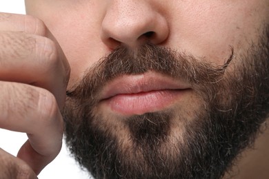 Photo of Young man with mustache on white background, closeup