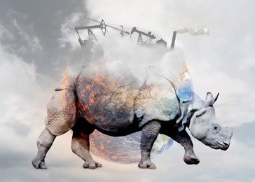 Double exposure of rhinoceros and conceptual image depicting Earth destroying by global warming and industrial pollution
