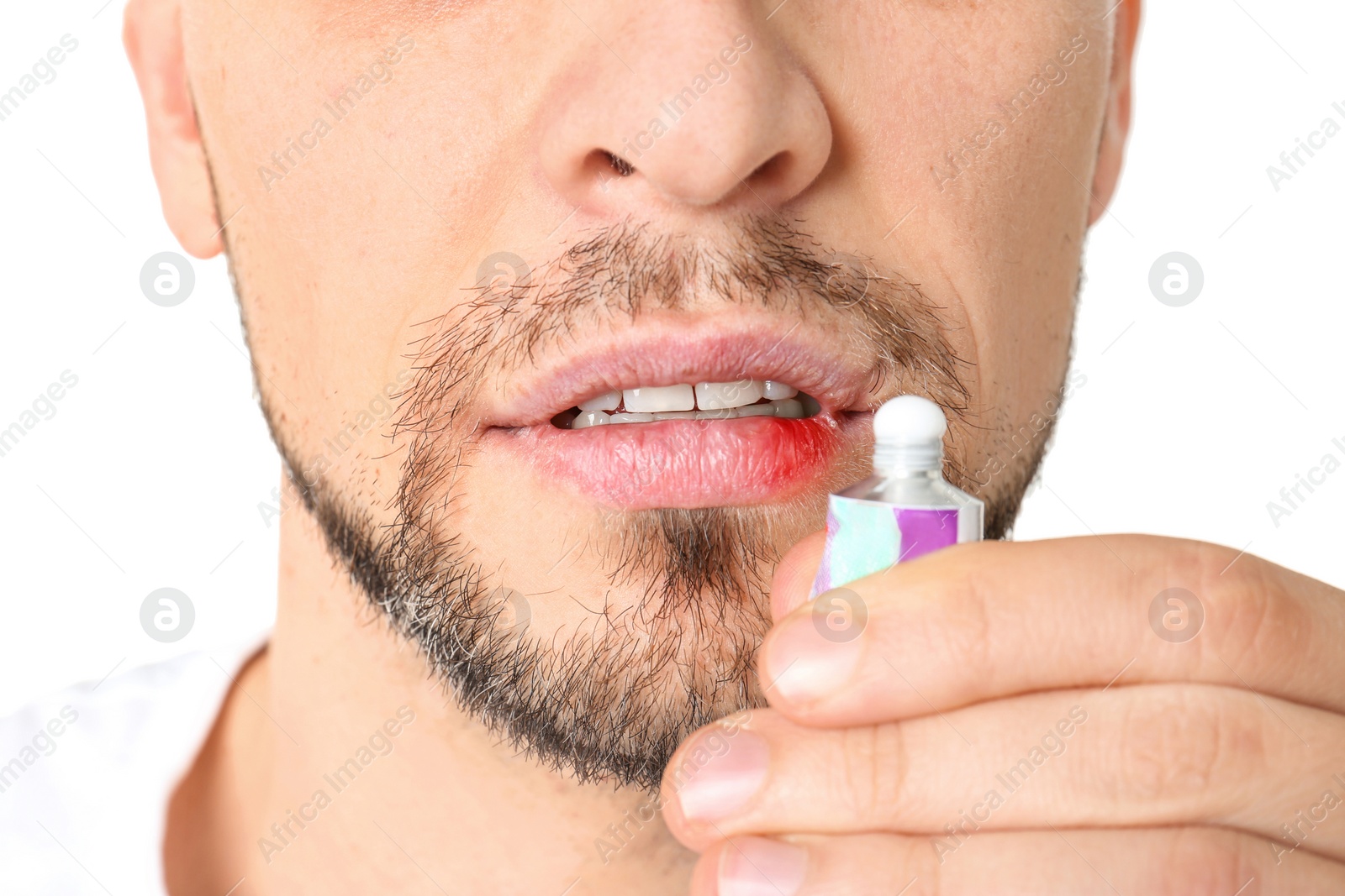 Photo of Man applying cream onto lips on white background, closeup